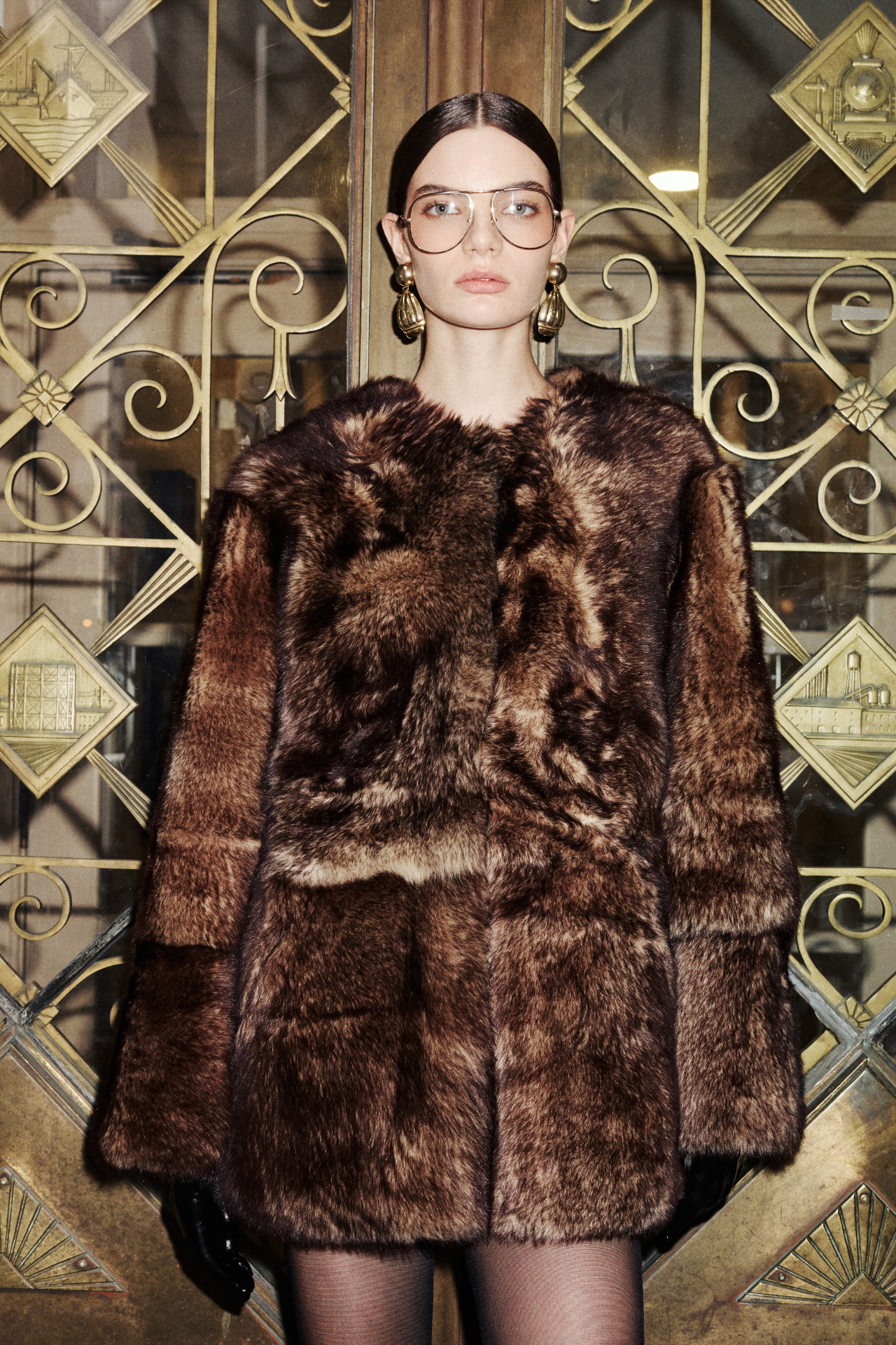 Wrap yourself in the luxurious warmth of this wool-out coat. This collarless outerwear piece offers an oversized fit for ultimate comfort and style. Featuring a convenient snap closure, this jacket is both fashionable and functional. Practical slash pockets and interior zip pockets add functionality to this elegant shearling wool coat. A perfect addition to your collection of fine coats.