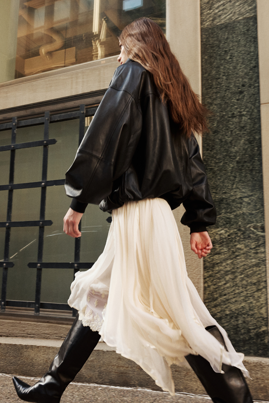 This stylish women's jacket is a chic piece of outerwear. Crafted from sleek leather, this coat features a modern, relaxed silhouette. It includes practical details such as front flap pockets and a gathered hem. This versatile leather jacket is perfect for adding an edgy yet sophisticated touch to any outfit. A must-have jacket for fashion-forward individuals seeking a contemporary coat option.