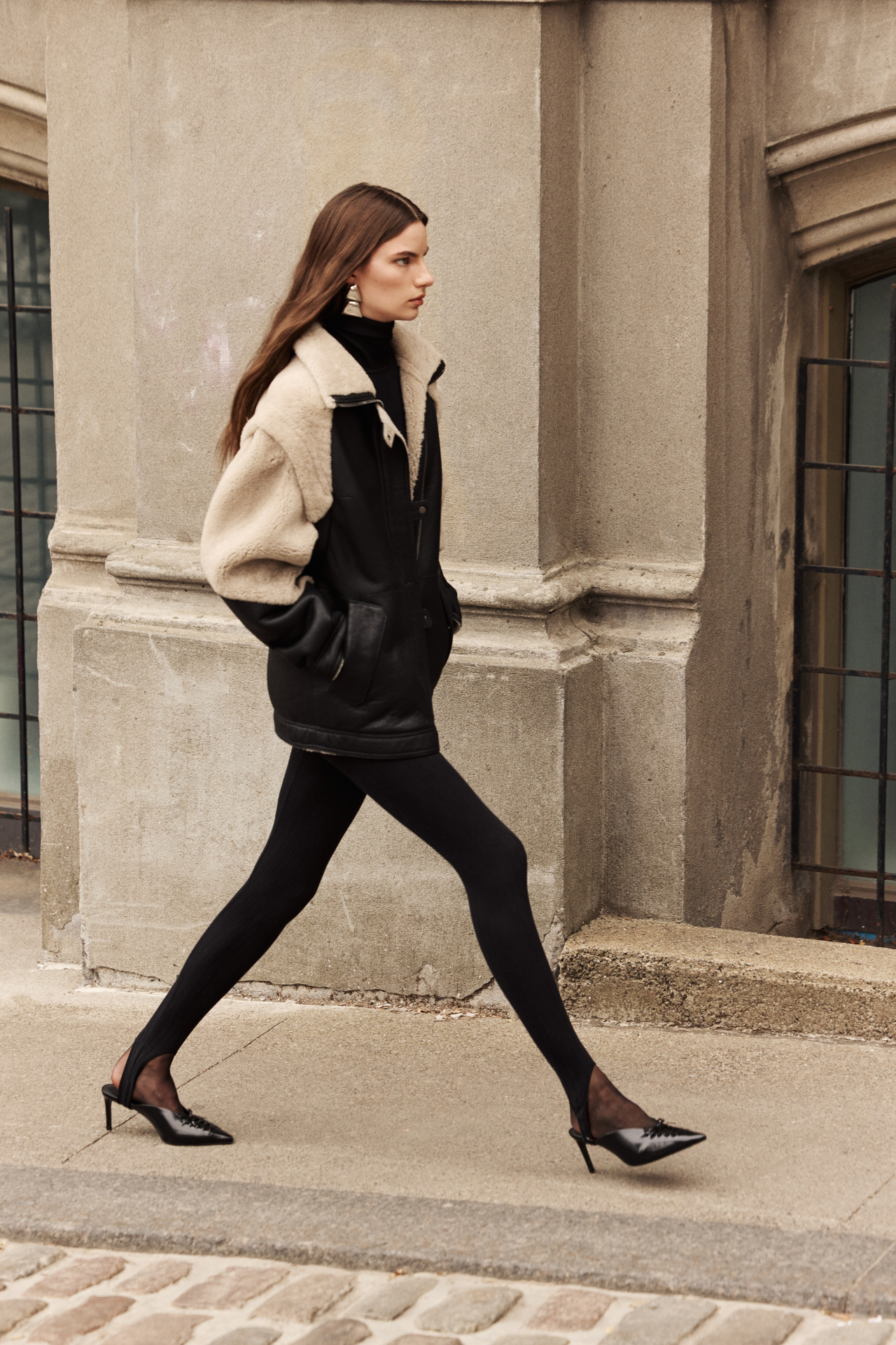 This stylish women's jacket is a versatile piece of outerwear: a chic nappa shearling design with cozy wool out details. This fashionable coat features a modern silhouette, a practical zip closure, and a convenient flap pocket. With removable sleeves, this clever jacket converts to a vest, offering multiple styling options. The luxurious shearling provides exceptional warmth and style. This adaptable outerwear piece is a must-have.