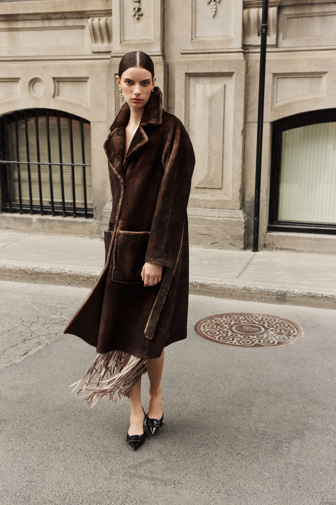 Wrap yourself in luxury with this reversible vintage-inspired suede coat. This versatile outerwear piece reverses to an ironed wool teddy for ultimate warmth. Featuring a large notch collar and relaxed dropped shoulders, this jacket offers a comfortable and stylish fit. Cinch your waist with the tie belt on the teddy side. Practical zip patch pockets adorn the suede coat side, while regular patch pockets appear on the reversed shearling-like teddy. A front button closure completes this exceptional coat.