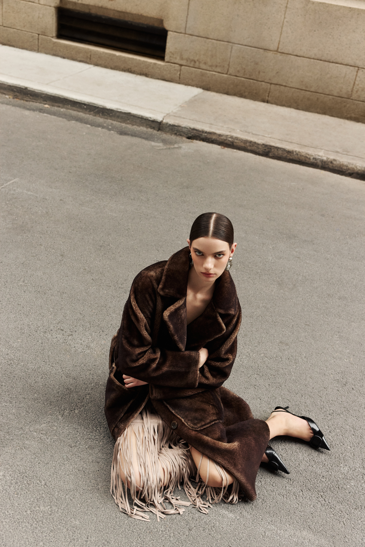 Wrap yourself in luxury with this reversible vintage-inspired suede coat. This versatile outerwear piece reverses to an ironed wool teddy for ultimate warmth. Featuring a large notch collar and relaxed dropped shoulders, this jacket offers a comfortable and stylish fit. Cinch your waist with the tie belt on the teddy side. Practical zip patch pockets adorn the suede coat side, while regular patch pockets appear on the reversed shearling-like teddy. A front button closure completes this exceptional coat.