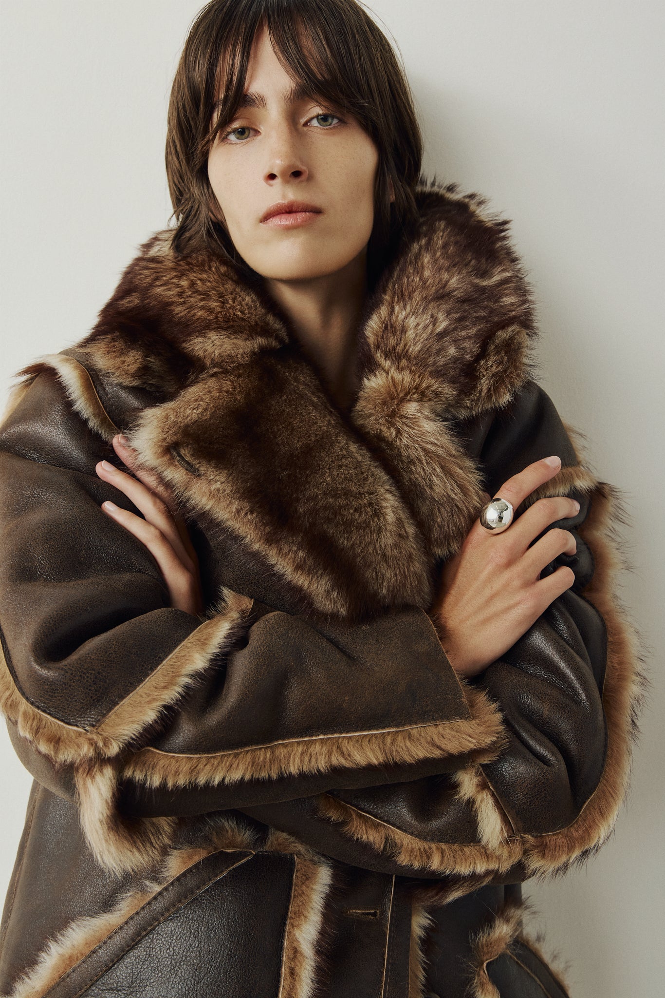 The LUREEN Coat is a luxury reversible semi-suede outerwear piece crafted in Burma Toscana. Designed to flip seamlessly from smooth semi-suede to plush Toscana wool teddy, it offers versatile styling for cold-weather layering. The wool-out Toscana seam detailing on the semi-suede side, combined with a drop shoulder and relaxed fit through shoulders, arms, and torso, creates effortless volume and structure. An oversized Toscana notch collar, patch pockets on both sides, and a front button closure complete th