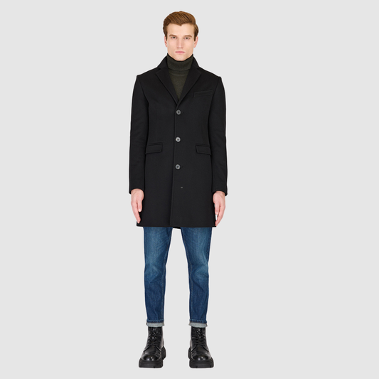 The Dylan Black Loro Piana Wool Coat captures refined sophistication through meticulous tailoring and Italian craftsmanship. Made from Loro Piana superfine wool, this single-breasted coat offers a slim fit through the arms and body, creating a sharp, modern silhouette ideal for both professional and evening wear. The notch collar, button-detailed cuffs, and flap side pockets add subtle sophistication, while the back vent ensures ease of movement and comfort. A single welt chest pocket completes this timeles