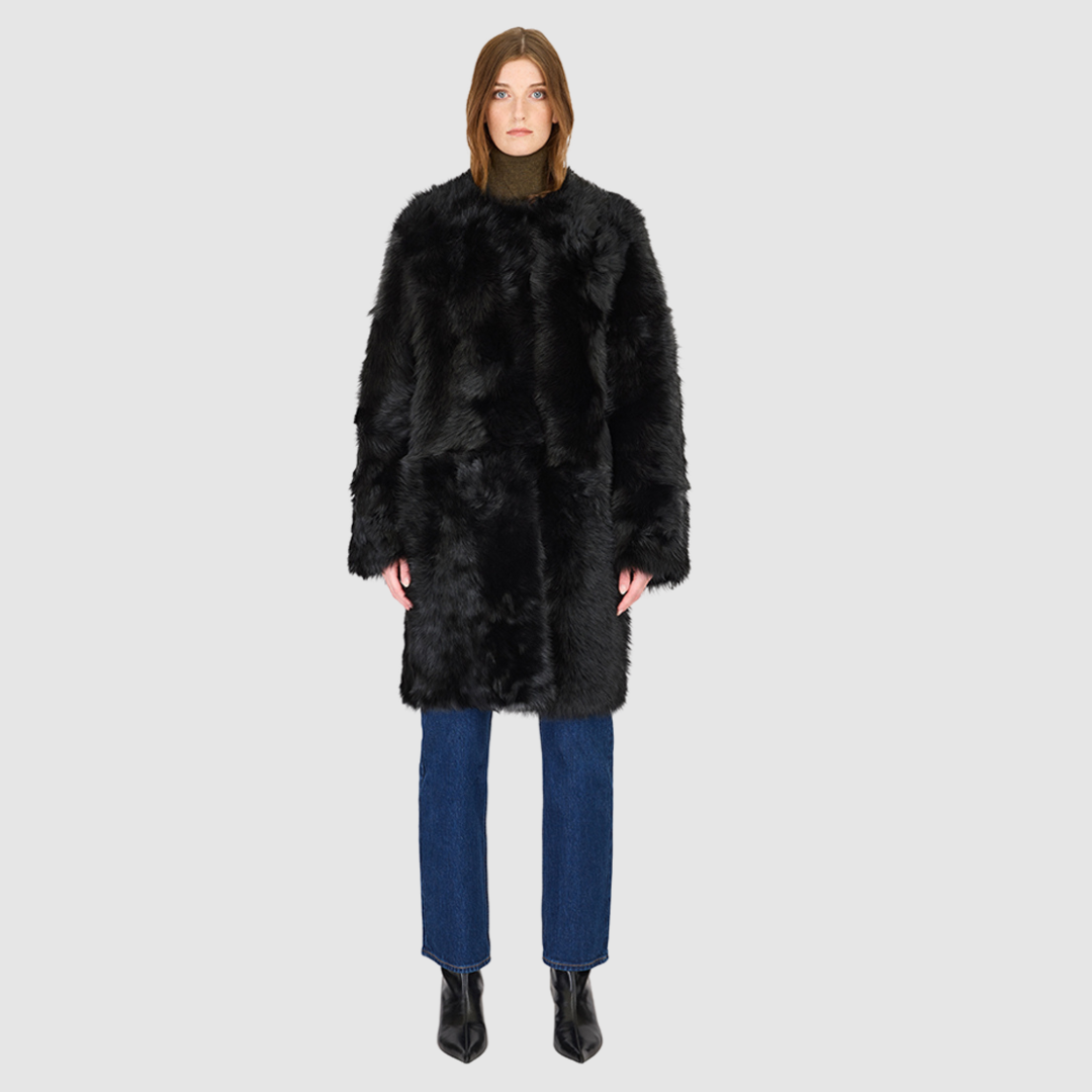 The ALLORA Jacket is a luxury reversible shearling teddy crafted in Jet Toscana for a rich and modern finish. Designed as a collarless regular fit silhouette, it effortlessly flips from plush wool-out shearling to a sleek nappa skin-out jacket, offering two looks in one. With its generous fit through the shoulders, arms, and torso, ALLORA balances comfort and style. Functional slash side pockets on both sides and a front snap closure complete this elevated women’s reversible shearling jacket.