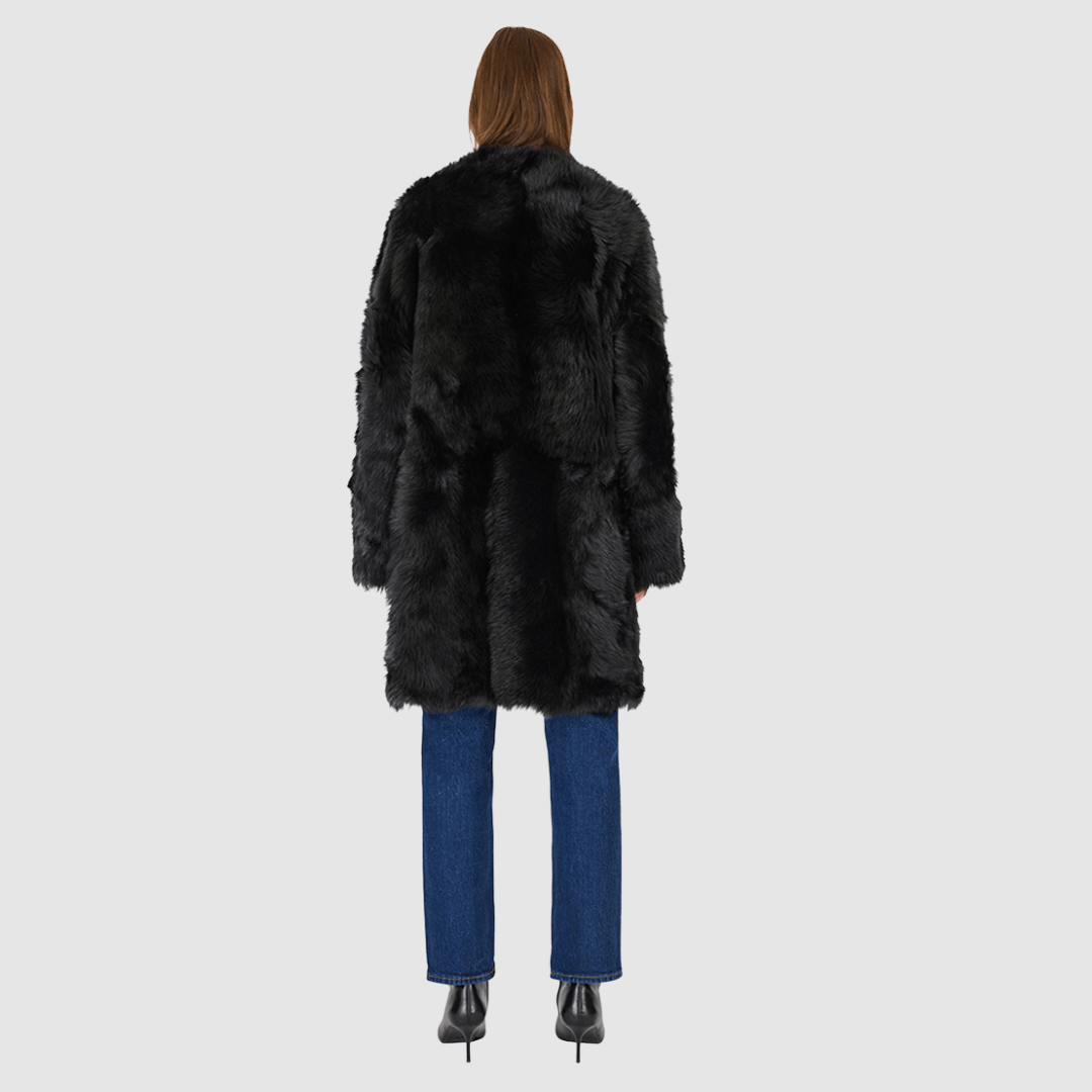 The ALLORA Jacket is a luxury reversible shearling teddy crafted in Jet Toscana for a rich and modern finish. Designed as a collarless regular fit silhouette, it effortlessly flips from plush wool-out shearling to a sleek nappa skin-out jacket, offering two looks in one. With its generous fit through the shoulders, arms, and torso, ALLORA balances comfort and style. Functional slash side pockets on both sides and a front snap closure complete this elevated women’s reversible shearling jacket.