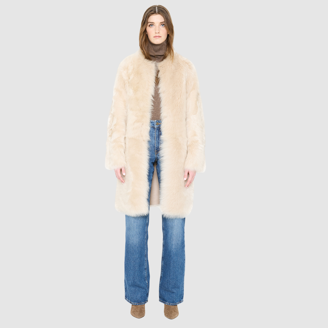 The ALLORA Jacket is a luxury reversible shearling teddy crafted in parchment toscana for a rich and modern finish. Designed as a collarless regular fitting silhouette, it effortlessly flips from plush wool-out shearling to a sleek suede skin-out jacket, offering two looks in one. With its generous fit through the shoulders, arms, and torso, ALLORA balances comfort and style. Functional slash side pockets on both sides and a front snap closure complete this elevated women’s reversible shearling jacket.