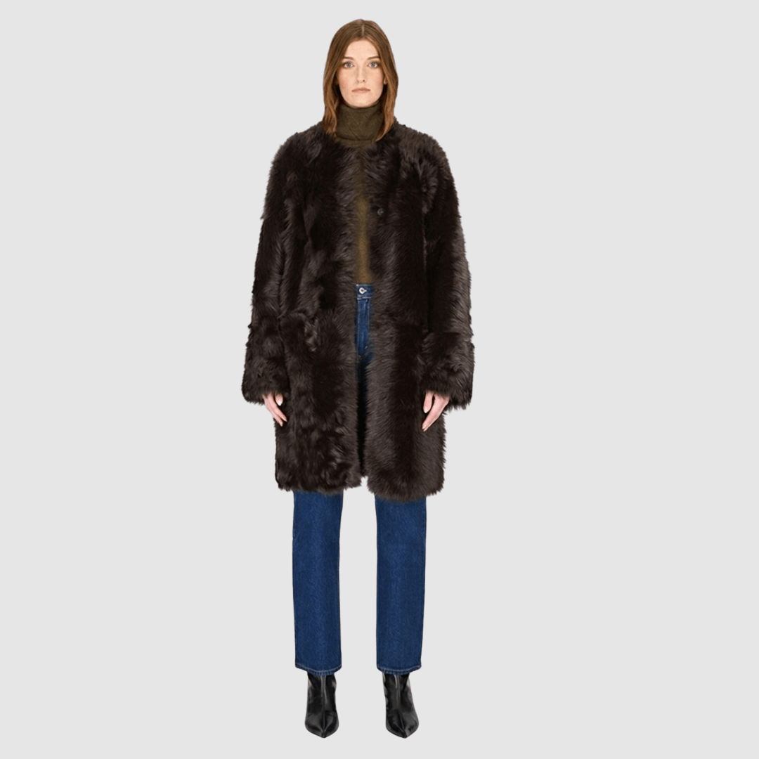 The ALLORA Jacket is a luxury reversible shearling teddy crafted in carbon toscana for a rich and modern finish. Designed as a collarless regular fit silhouette, it effortlessly flips from plush wool-out shearling to a sleek nappa skin-out jacket, offering two looks in one. With its generous fit through the shoulders, arms, and torso, ALLORA balances comfort and style. Functional slash side pockets on both sides and a front snap closure complete this elevated women’s reversible shearling jacket.