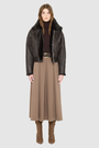 The CLARITY shearling bomber jacket offers a modern take on the classic bomber jacket, combining rugged function with luxurious texture. Crafted in a rich chocolate brown nappa leather and plush, dark rasado shearling wool interior, it delivers an elevated cold-weather look. Designed with a drop shoulder and a high shearling collar, it balances structure with relaxed ease. A tonal ribbed knit waistband, structural paneling, and clean hardware details lend utility to this elegant semi-fitted style