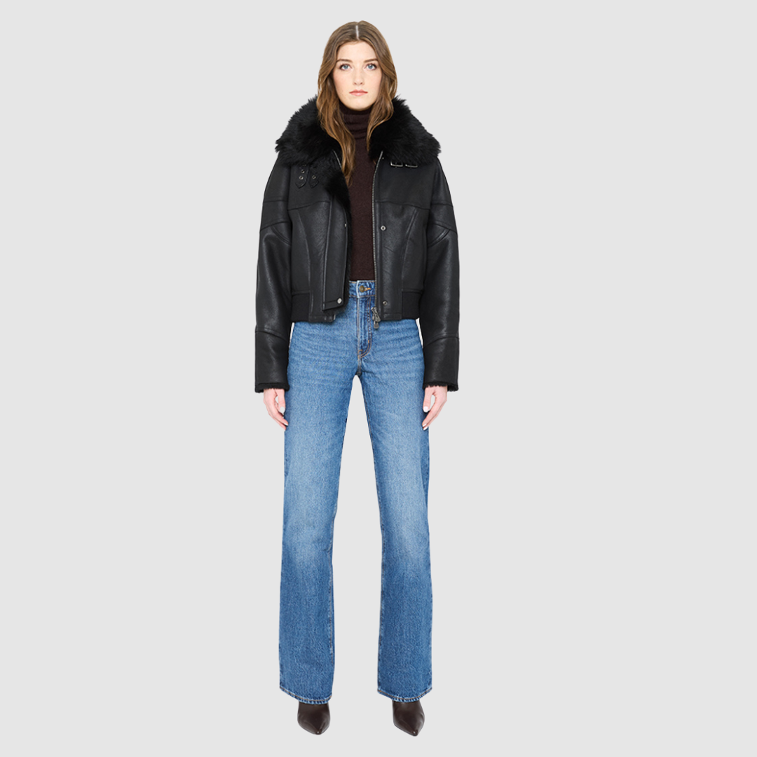 The CLARITY shearling bomber jacket offers a modern take on the classic bomber jacket, combining rugged function with luxurious texture. Crafted in a rich jet black nappa leather and plush, dark rasado shearling wool interior, it delivers an elevated cold-weather look. Designed with a drop shoulder and a high shearling collar, it balances structure with relaxed ease. A tonal ribbed knit waistband, structural paneling, and clean hardware details lend utility to this elegant semi-fitted style