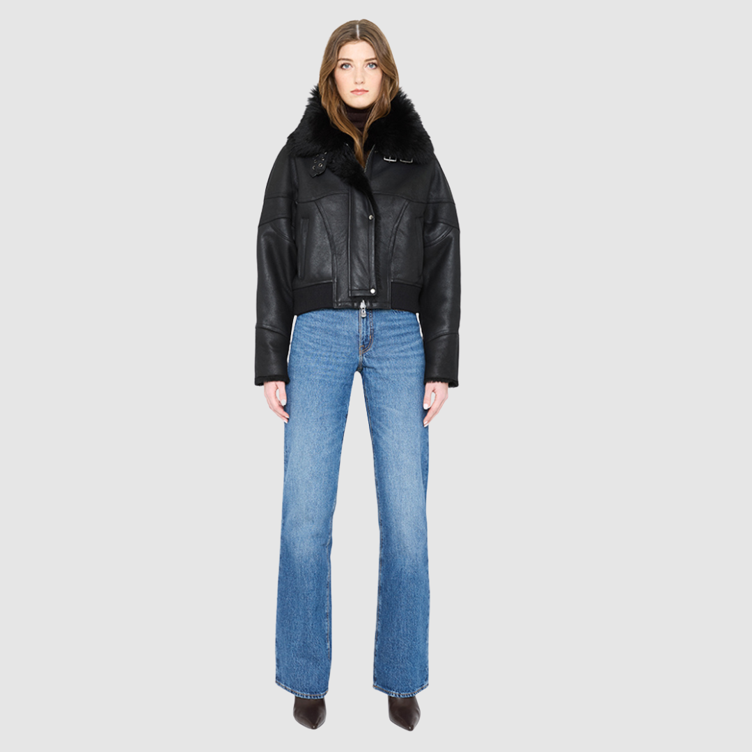 The CLARITY shearling bomber jacket offers a modern take on the classic bomber jacket, combining rugged function with luxurious texture. Crafted in a rich jet black nappa leather and plush, dark rasado shearling wool interior, it delivers an elevated cold-weather look. Designed with a drop shoulder and a high shearling collar, it balances structure with relaxed ease. A tonal ribbed knit waistband, structural paneling, and clean hardware details lend utility to this elegant semi-fitted style