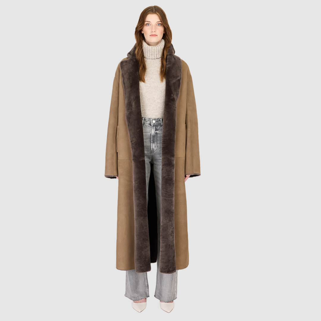 The DANIELLE Duster is a statement in heritage-inspired luxury and modern versatility. Crafted in kangaroo suede leather and plush curly wool shearling, this reversible oversized coat transitions effortlessly from sleek leather to cozy teddy texture. Its elongated silhouette is enhanced with a slight drop shoulder, back vent, and double-breasted button closure, creating timeless elegance with functional edge. Practical single welt pockets on the suede side and slash pockets on the wool side.