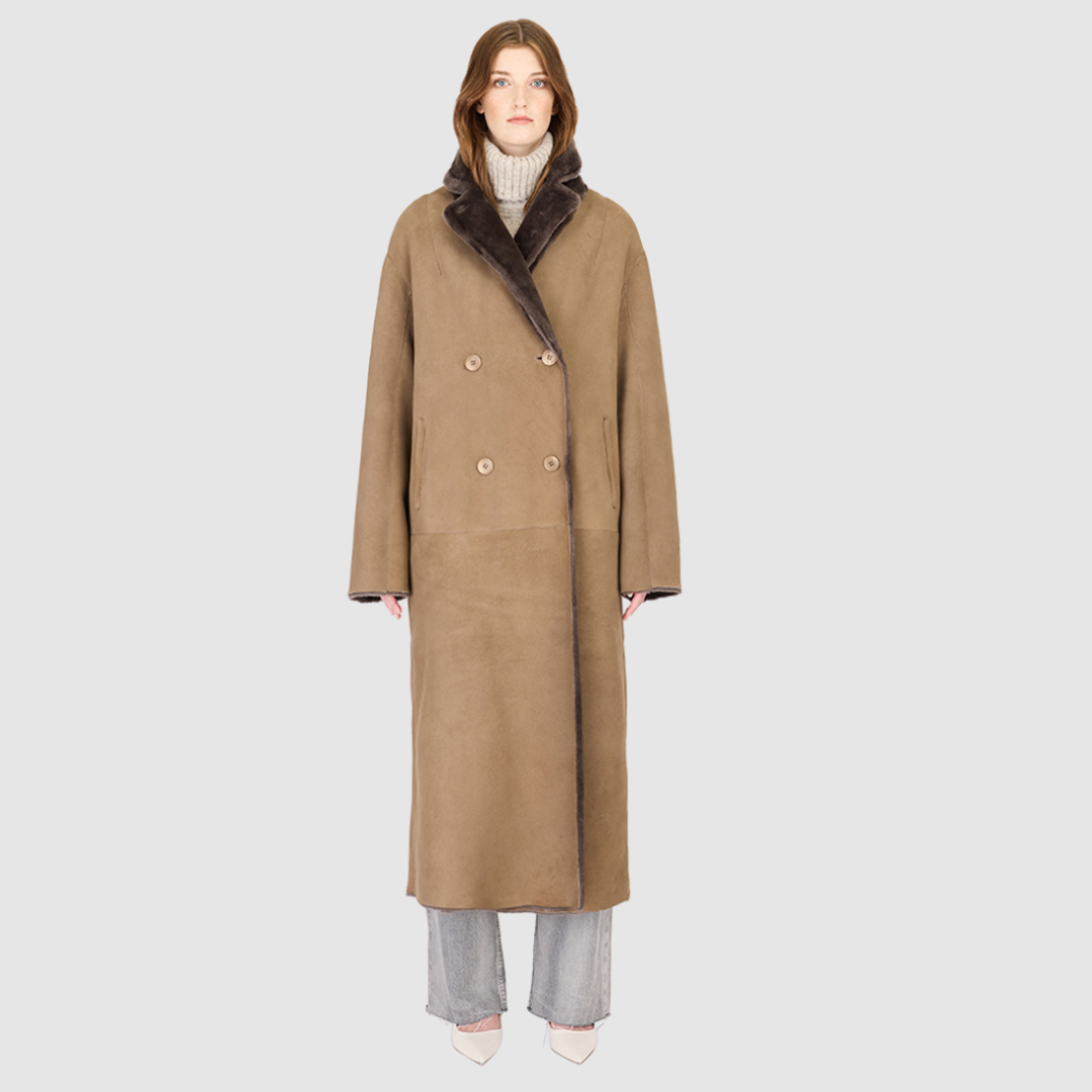 The DANIELLE Duster is a statement in heritage-inspired luxury and modern versatility. Crafted in kangaroo suede leather and plush curly wool shearling, this reversible oversized coat transitions effortlessly from sleek leather to cozy teddy texture. Its elongated silhouette is enhanced with a slight drop shoulder, back vent, and double-breasted button closure, creating timeless elegance with functional edge. Practical single welt pockets on the suede side and slash pockets on the wool side.