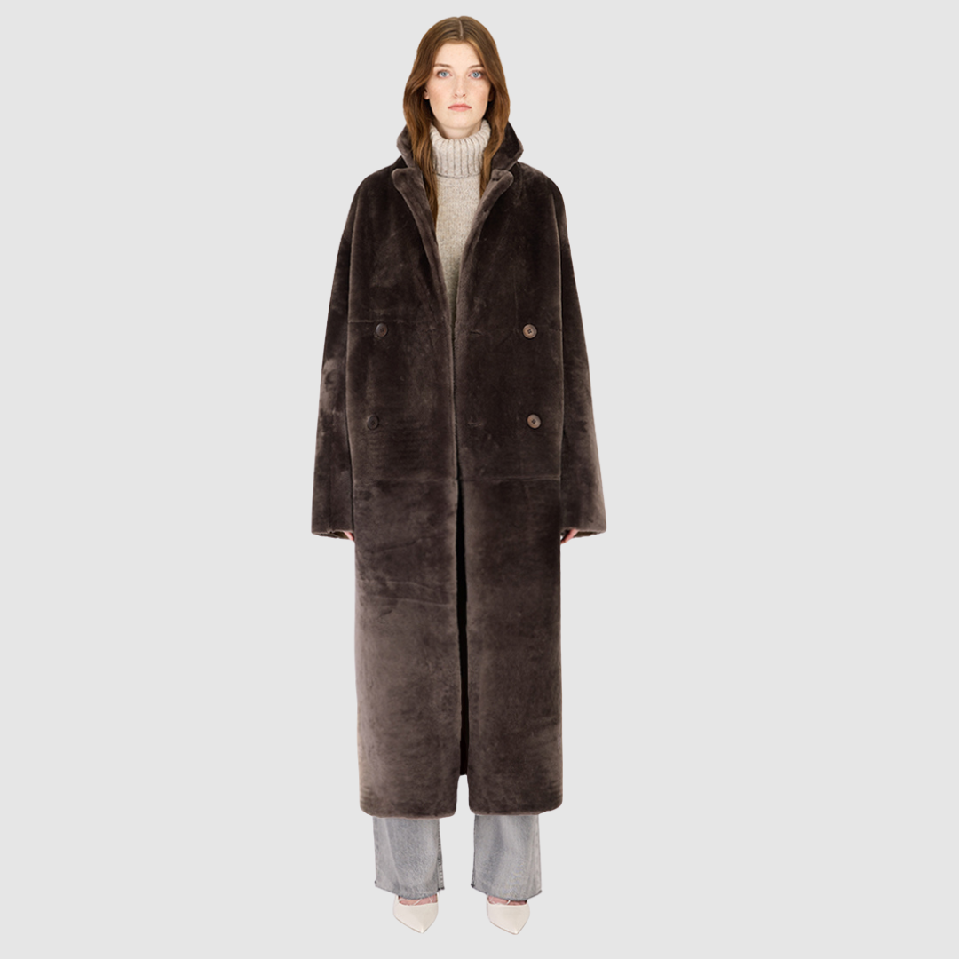 The DANIELLE Duster is a statement in heritage-inspired luxury and modern versatility. Crafted in kangaroo suede leather and plush curly wool shearling, this reversible oversized coat transitions effortlessly from sleek leather to cozy teddy texture. Its elongated silhouette is enhanced with a slight drop shoulder, back vent, and double-breasted button closure, creating timeless elegance with functional edge. Practical single welt pockets on the suede side and slash pockets on the wool side.