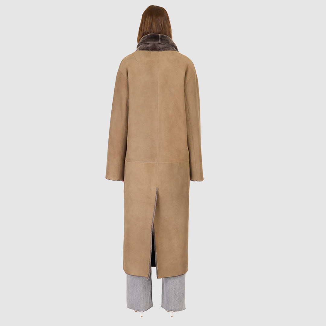 The DANIELLE Duster is a statement in heritage-inspired luxury and modern versatility. Crafted in kangaroo suede leather and plush curly wool shearling, this reversible oversized coat transitions effortlessly from sleek leather to cozy teddy texture. Its elongated silhouette is enhanced with a slight drop shoulder, back vent, and double-breasted button closure, creating timeless elegance with functional edge. Practical single welt pockets on the suede side and slash pockets on the wool side.