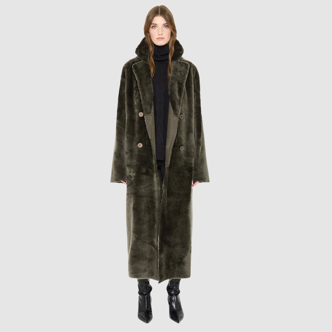 The DANIELLE Duster is a statement in heritage-inspired luxury and modern versatility. Crafted in khaki suede leather and plush curly wool shearling, this reversible oversized coat transitions effortlessly from sleek leather to cozy teddy texture. Its elongated silhouette is enhanced with a slight drop shoulder, back vent, and double-breasted button closure, creating timeless elegance with functional edge. Practical single welt pockets on the suede side and slash pockets on the wool side.