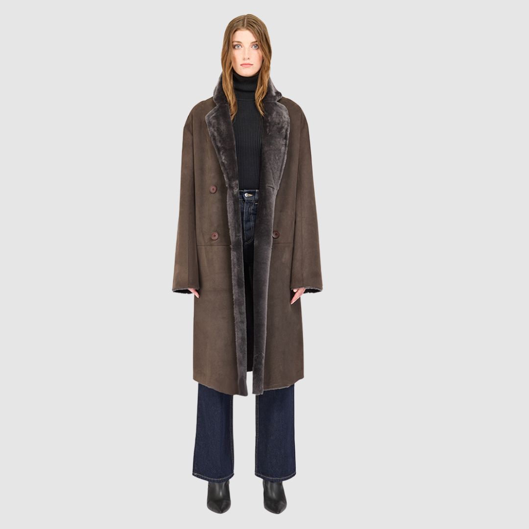 The ELLE Coat is a heritage-inspired oversized reversible shearling piece crafted in a cappuccino suede ironed wool teddy. Designed to transition seamlessly from smooth suede to plush wool-out texture, this versatile style blends timeless tailoring with modern après-ski elegance. A slight drop shoulder, double-breasted button closure, and back vent add structure to its oversized silhouette. Functional single welt pockets on the suede side and slash pockets on the ironed wool side make ELLE luxurious coat