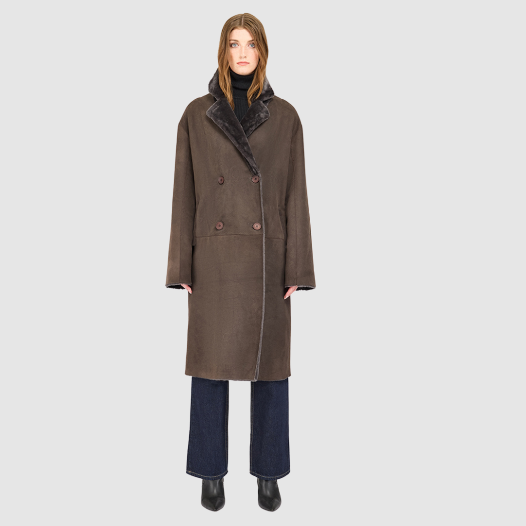 The ELLE Coat is a heritage-inspired oversized reversible shearling piece crafted in a cappuccino suede ironed wool teddy. Designed to transition seamlessly from smooth suede to plush wool-out texture, this versatile style blends timeless tailoring with modern après-ski elegance. A slight drop shoulder, double-breasted button closure, and back vent add structure to its oversized silhouette. Functional single welt pockets on the suede side and slash pockets on the ironed wool side make ELLE luxurious coat