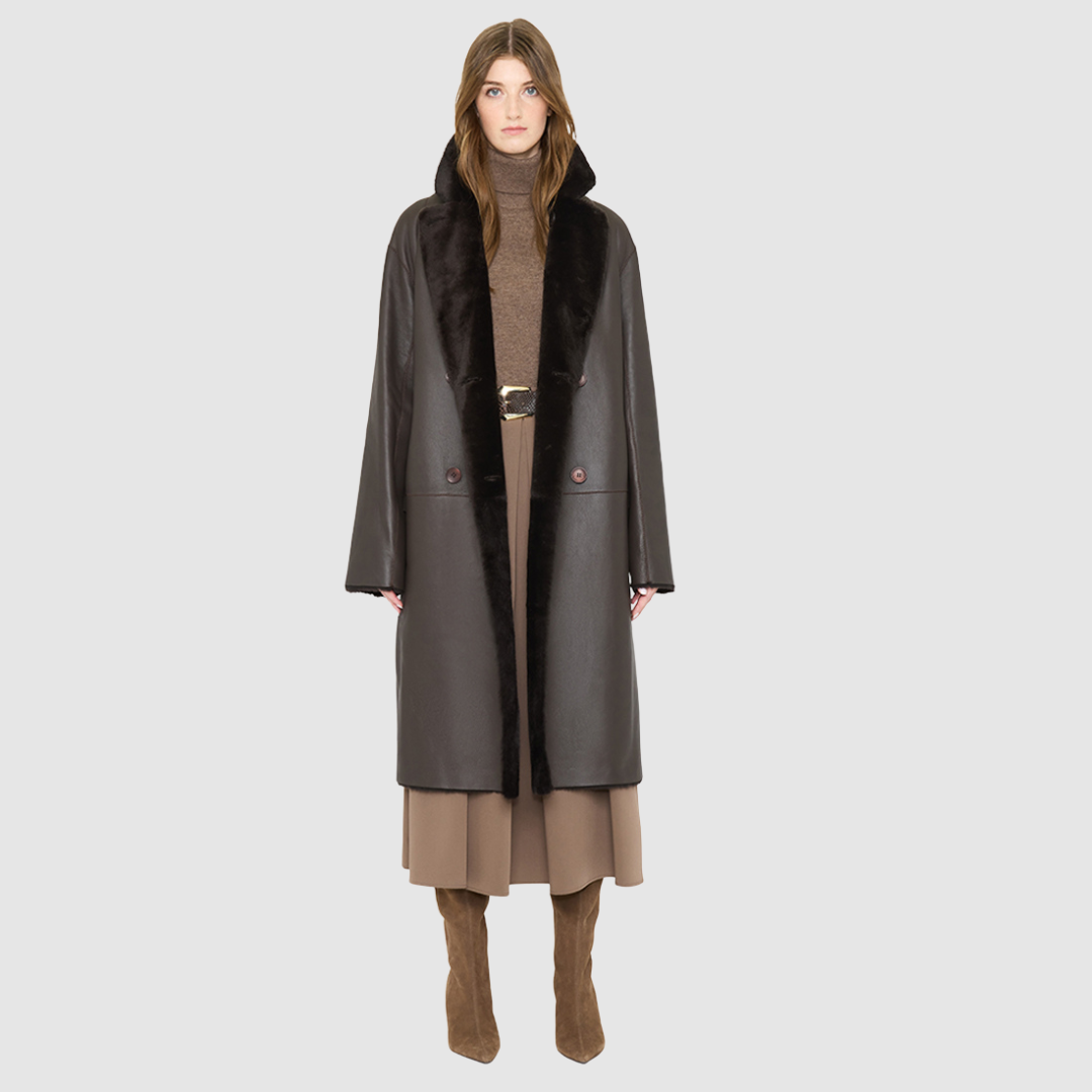 The ELLE Coat is a heritage-inspired oversized reversible shearling piece crafted in a chocolate nappa ironed wool teddy. Designed to transition seamlessly from smooth suede to plush wool-out texture, this versatile style blends timeless tailoring with modern après-ski elegance. A slight drop shoulder, double-breasted button closure, and back vent add structure to its oversized silhouette. Functional single welt pockets on the suede side and slash pockets on the ironed wool side 