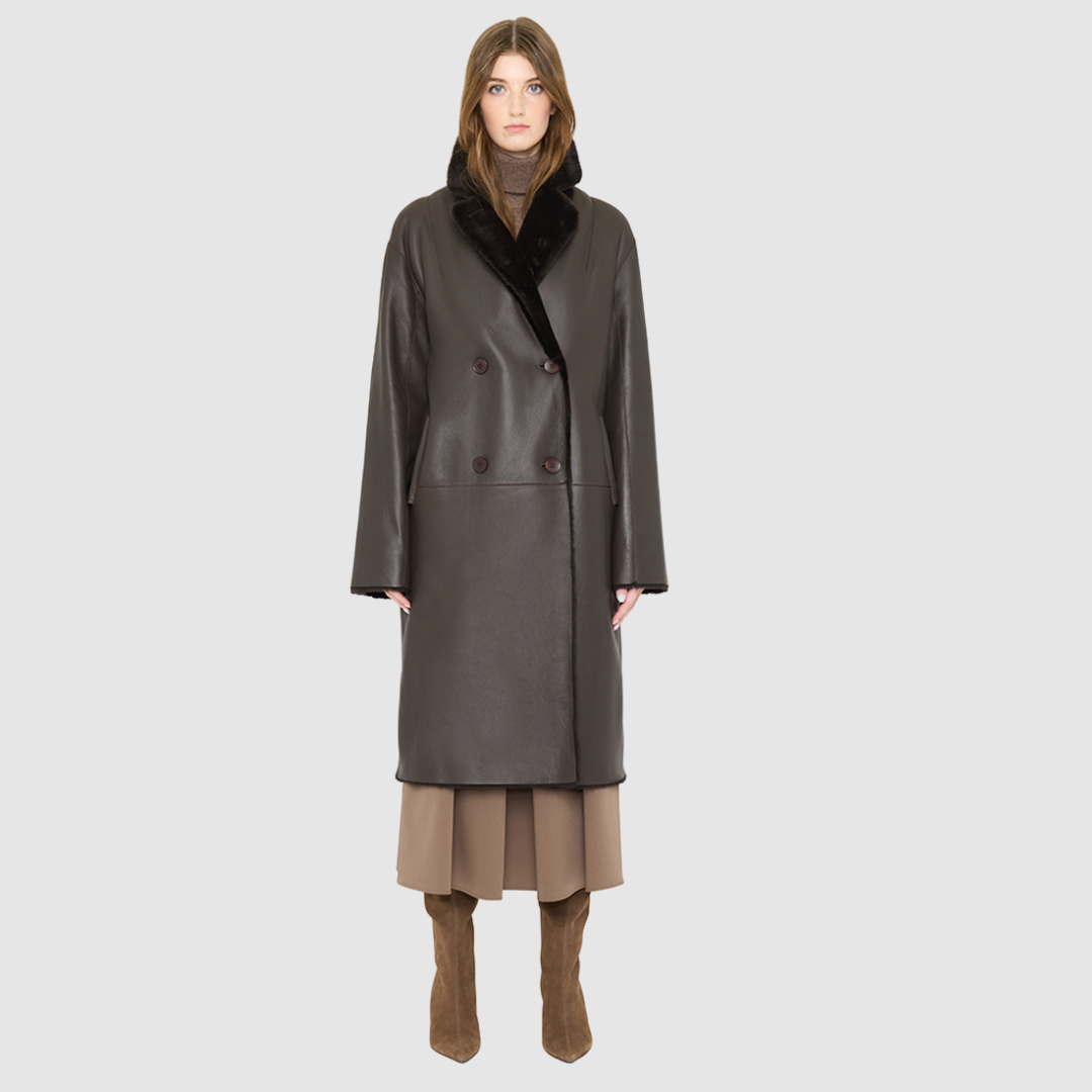 The ELLE Coat is a heritage-inspired oversized reversible shearling piece crafted in a chocolate nappa ironed wool teddy. Designed to transition seamlessly from smooth suede to plush wool-out texture, this versatile style blends timeless tailoring with modern après-ski elegance. A slight drop shoulder, double-breasted button closure, and back vent add structure to its oversized silhouette. Functional single welt pockets on the suede side and slash pockets on the ironed wool side 