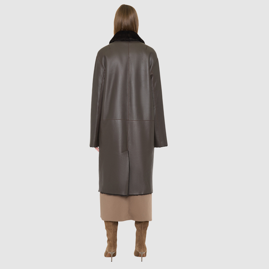 The ELLE Coat is a heritage-inspired oversized reversible shearling piece crafted in a chocolate nappa ironed wool teddy. Designed to transition seamlessly from smooth suede to plush wool-out texture, this versatile style blends timeless tailoring with modern après-ski elegance. A slight drop shoulder, double-breasted button closure, and back vent add structure to its oversized silhouette. Functional single welt pockets on the suede side and slash pockets on the ironed wool side 