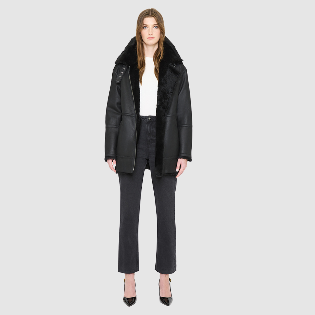 JILL is a heritage-inspired reversible medium-length shearling car coat crafted in jet black matte nappa leather with smooth ironed wool teddy on the reverse. Designed for a relaxed silhouette with regular shoulders, an exaggerated spread collar with adjustable leather strap detail, and a straight fit, JILL combines modern edge with timeless texture. Functional deep patch pockets on the wool side, clean welt pockets on the nappa side, and a heavy-duty front zip closure 