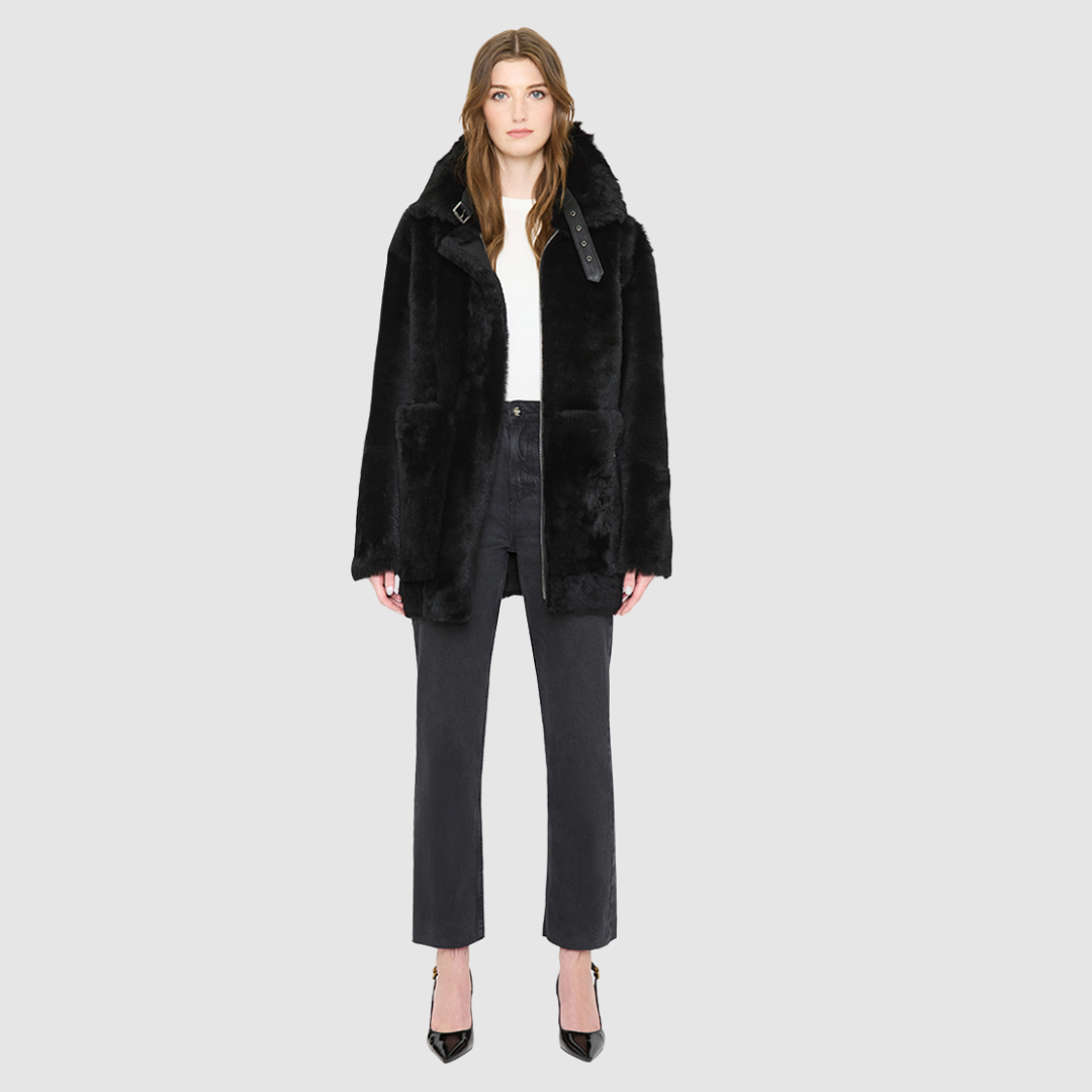 JILL is a heritage-inspired reversible medium-length shearling car coat crafted in jet black matte nappa leather with smooth ironed wool teddy on the reverse. Designed for a relaxed silhouette with regular shoulders, an exaggerated spread collar with adjustable leather strap detail, and a straight fit, JILL combines modern edge with timeless texture. Functional deep patch pockets on the wool side, clean welt pockets on the nappa side, and a heavy-duty front zip closure 