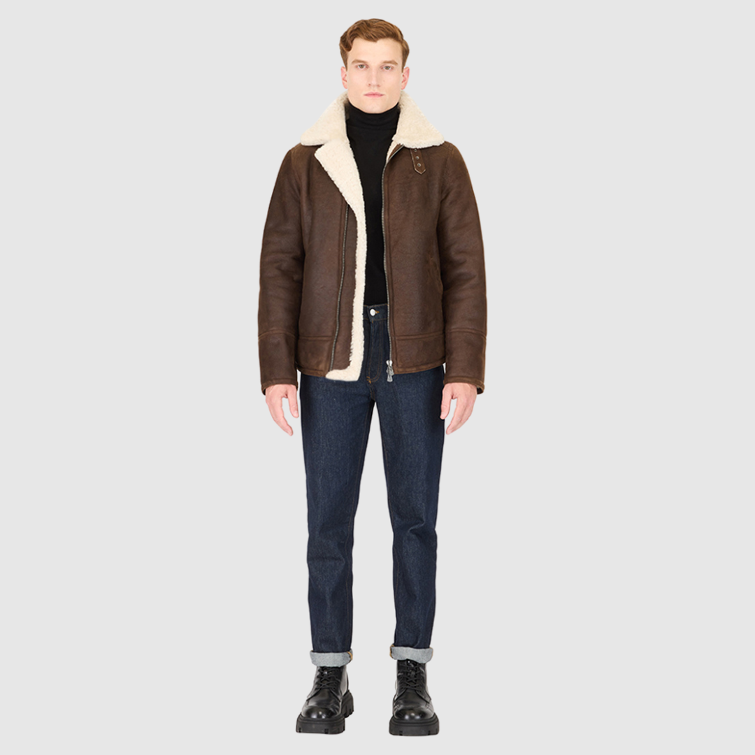 The Kane Arabica Shearling Moto combines heritage craftsmanship with modern moto design. Crafted from supple nappa leather with a plush curly wool collar, it fits comfortably through the shoulders and chest for ease of movement. Featuring a notch collar with buckle detailing, interior patch pockets, and exterior single welt side pockets, it balances functional utility with polished style. A front zip closure completes the sleek, timeless silhouette.