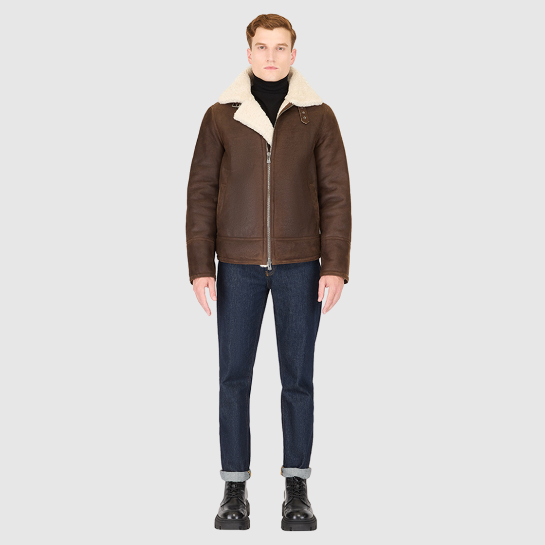 The Kane Arabica Shearling Moto combines heritage craftsmanship with modern moto design. Crafted from supple nappa leather with a plush curly wool collar, it fits comfortably through the shoulders and chest for ease of movement. Featuring a notch collar with buckle detailing, interior patch pockets, and exterior single welt side pockets, it balances functional utility with polished style. A front zip closure completes the sleek, timeless silhouette.