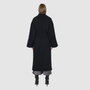 The LEONA Coat is a modern full-length silhouette crafted in a premium black wool blend. Designed with drop shoulders, wide kimono-inspired sleeves, and an easy, relaxed drape, it delivers effortless volume and architectural lines. A clean collarless V-neckline and single-breasted button closure give it a sleek, minimalist finish, while a matching tie belt and elasticized back waist offer versatile styling. Fully lined for comfort, LEONA serves as a definitive statement coat for elevated cold-weather 