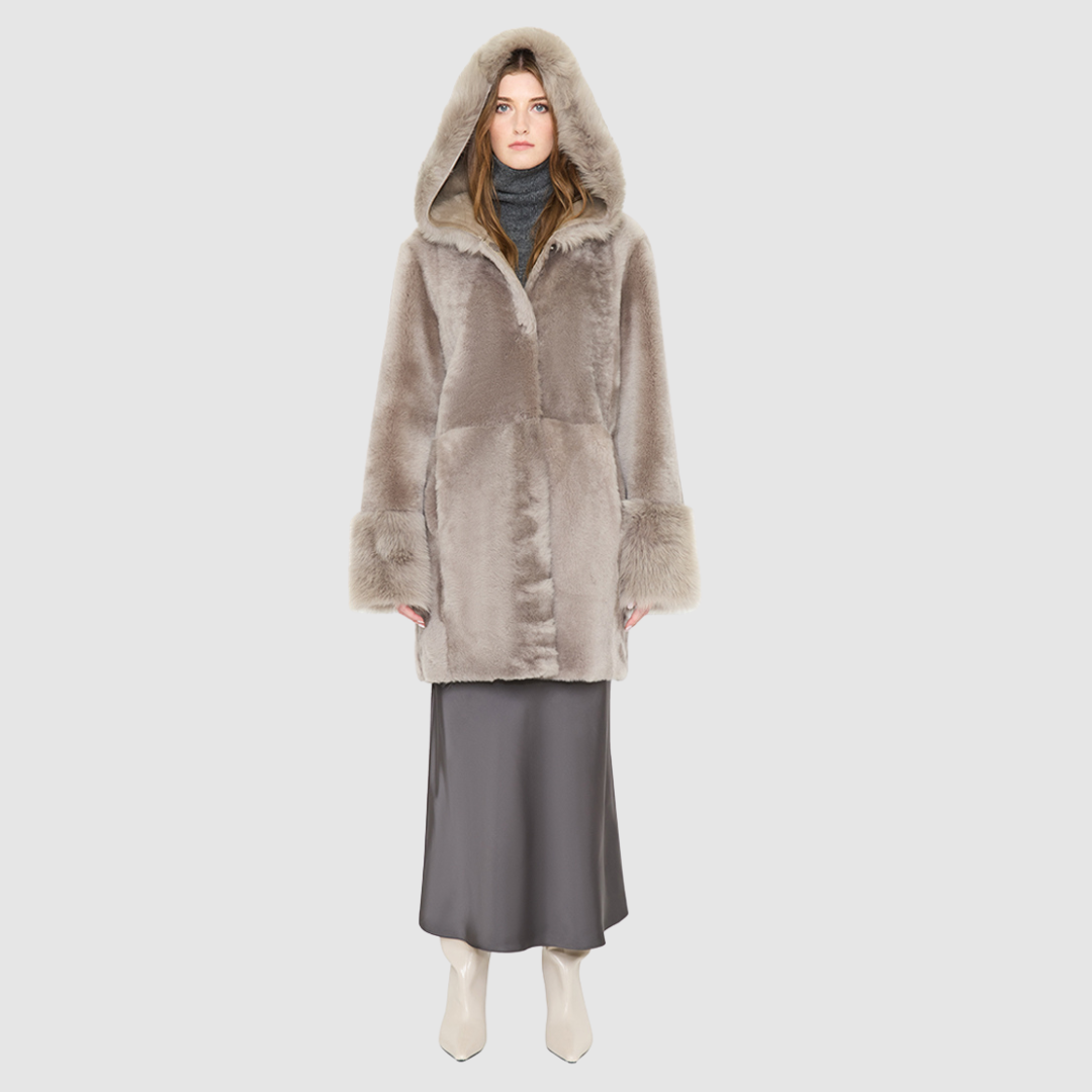 The LOVER reversible shearling jacket offers a modern take on the classic hooded long coat, combining rugged function with luxurious texture. Crafted in a rich smoked quartz suede that reverses to a plush, toscana rasado wool interior, it delivers two distinct looks in one. Designed with a regular shoulder and an oversized shearling hood, it balances structure with relaxed ease. Clean tailored panels and versatile integrated pocketing lend utility to this elegant semi-fitted style