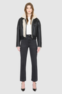 The LUMI Jacket is a heritage-inspired cropped shearling aviator crafted from black nappa leather and plush cream wool detailing for modern texture and dimension. Its regular shoulder and tailored cropped silhouette create a sleek, contemporary fit, while architectural paneled lines add a clean, minimalist edge. Functional exterior welt pockets, front zip closure, and a thick tonal ribbed knit waistband make LUMI as practical as it is stylish, perfect for après-ski layering or urban winter looks.