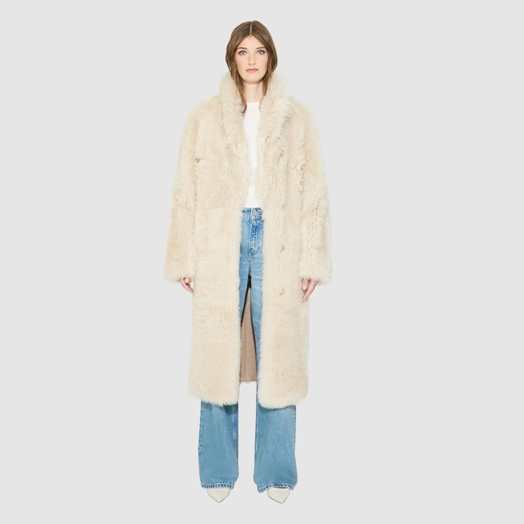 OMEGA introduces an element of understated luxury to cold-weather dressing, offering a longline silhouette engineered for seasonal transition. This exquisite investment outerwear piece pairs a suede exterior skin with a rich, magnificent semi curly toscana wool teddy on the reverse side. Designed to shift seamlessly from a dramatic, texture-forward profile to a classic, minimalist skin-out aesthetic, this fully reversible coat adapts effortlessly to your outfit. 