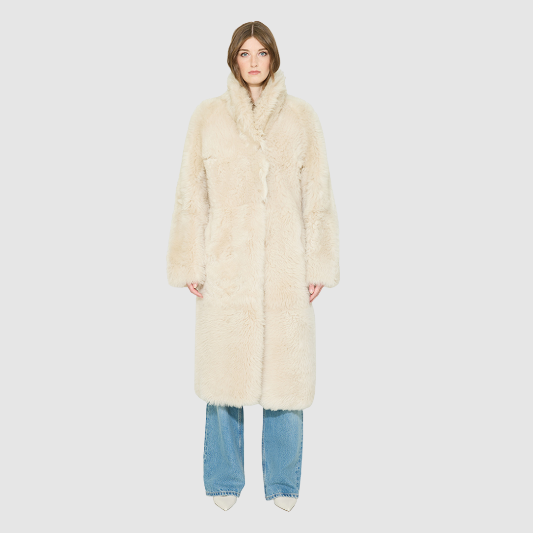 OMEGA introduces an element of understated luxury to cold-weather dressing, offering a longline silhouette engineered for seasonal transition. This exquisite investment outerwear piece pairs a suede exterior skin with a rich, magnificent semi curly toscana wool teddy on the reverse side. Designed to shift seamlessly from a dramatic, texture-forward profile to a classic, minimalist skin-out aesthetic, this fully reversible coat adapts effortlessly to your outfit. 