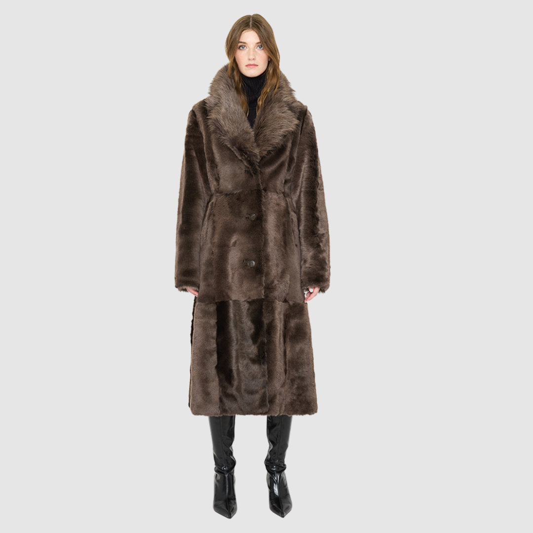 The PANDORA Shearling Coat offers a modern take on the classic long coat, combining rugged function with luxurious texture. Crafted with plush toscana wool shearling, it delivers a timelessly elegant cold-weather look. Designed with a regular shoulder and an oversized notch collar, it masterfully balances structure with relaxed ease. Clean tailored panels and versatile side slit pockets lend utility to this elegant semi-fitted style, making PANDORA ideal for heritage outerwear lovers