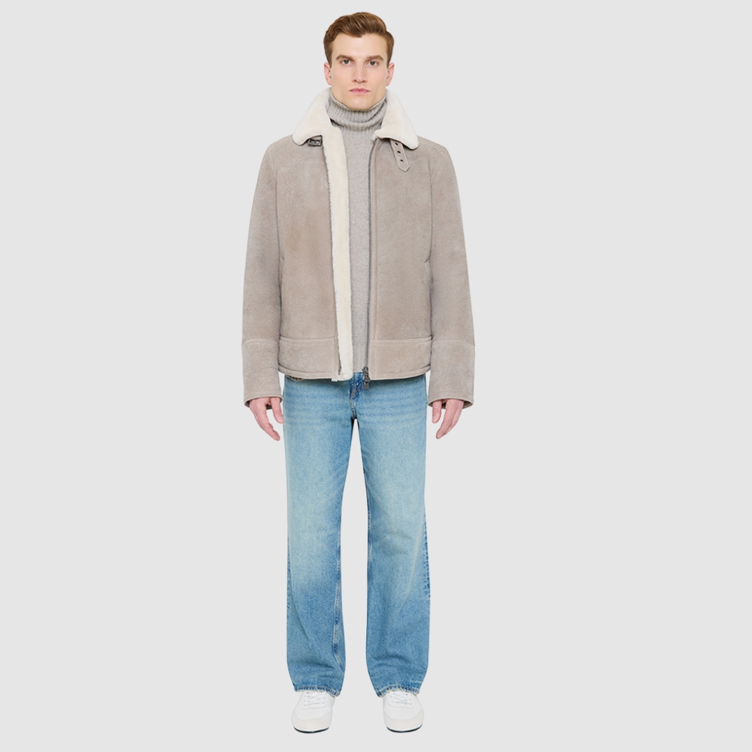 The KANE in Rhino colored shearling moto combines heritage craftsmanship with modern moto design. Crafted from supple nappa leather with a plush curly wool collar, it fits comfortably through the shoulders and chest for ease of movement. Featuring a notch collar with buckle detailing, interior patch pockets, and exterior single welt side pockets, it balances functional utility with polished style. A front zip closure completes the sleek, timeless silhouette.