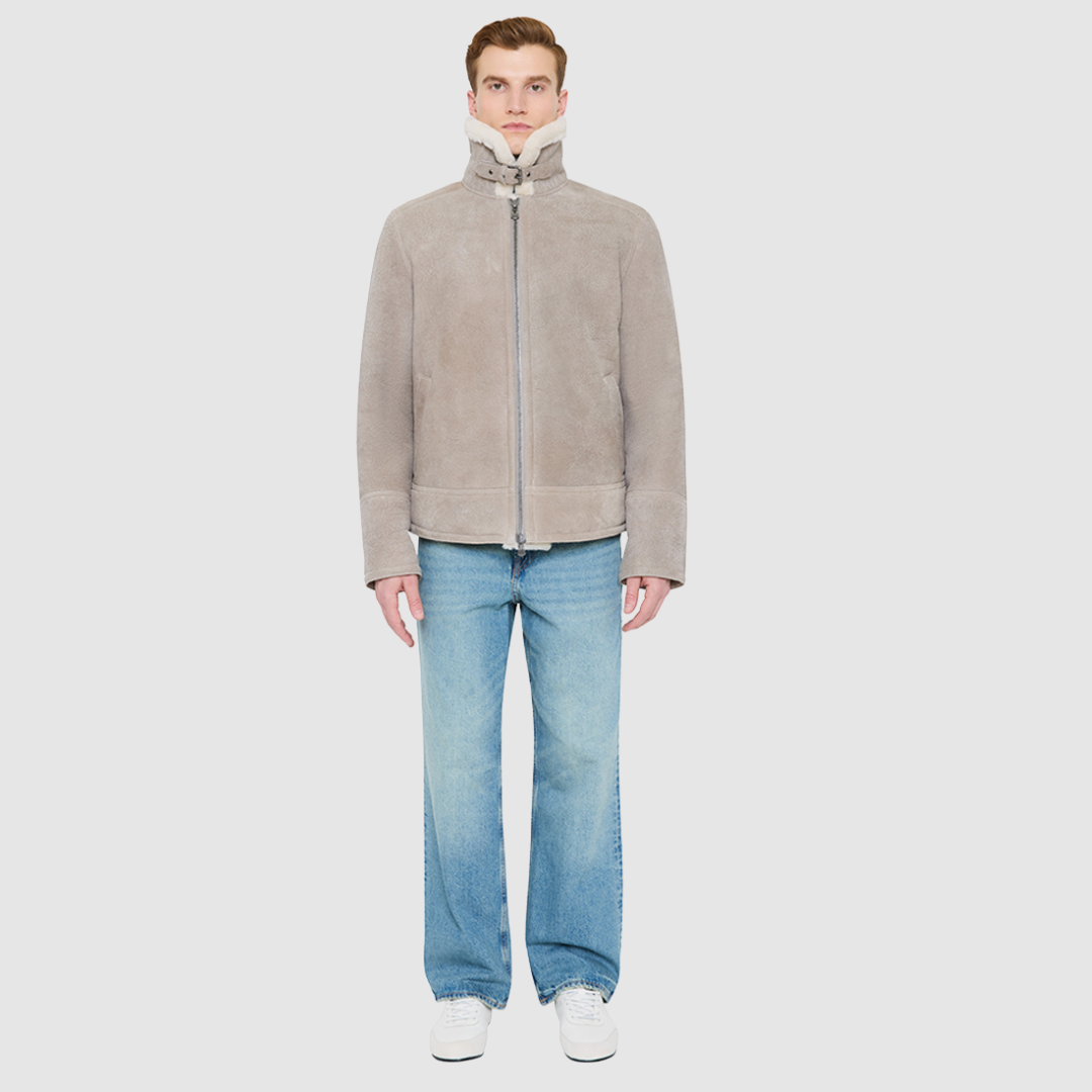 The KANE in Rhino colored shearling moto combines heritage craftsmanship with modern moto design. Crafted from supple nappa leather with a plush curly wool collar, it fits comfortably through the shoulders and chest for ease of movement. Featuring a notch collar with buckle detailing, interior patch pockets, and exterior single welt side pockets, it balances functional utility with polished style. A front zip closure completes the sleek, timeless silhouette.