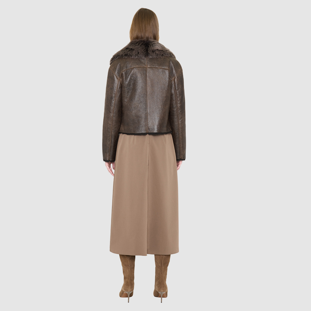 VRILL redefines alpine chic with a sharp, asymmetric profile tailored for effortless seasonal transitions. This cold-weather staple frames the body beautifully, pairing a refined matte nappa leather exterior with a uniform, plush ironed wool interior. Engineered for ultimate versatility across changing climates, the design transitions seamlessly from a classic skin-out moto jacket to a texture-forward statement piece complete with an exaggerated collar.