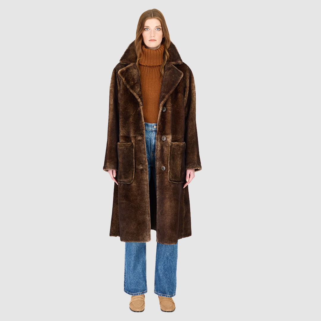 The ZIRA Coat is a heritage-inspired vintage reversible shearling jacket crafted in burma nappa and iron wool. Designed to flip effortlessly from sleek nappa to plush iron wool teddy, it delivers versatile styling for both après-ski sophistication and everyday cold-weather elegance. Featuring a relaxed dropped shoulder, notch collar, and 3-button closure, ZIRA combines modern tailoring with timeless texture. Practical zip pockets on the nappa side and patch pockets on the teddy side, along with tie belt