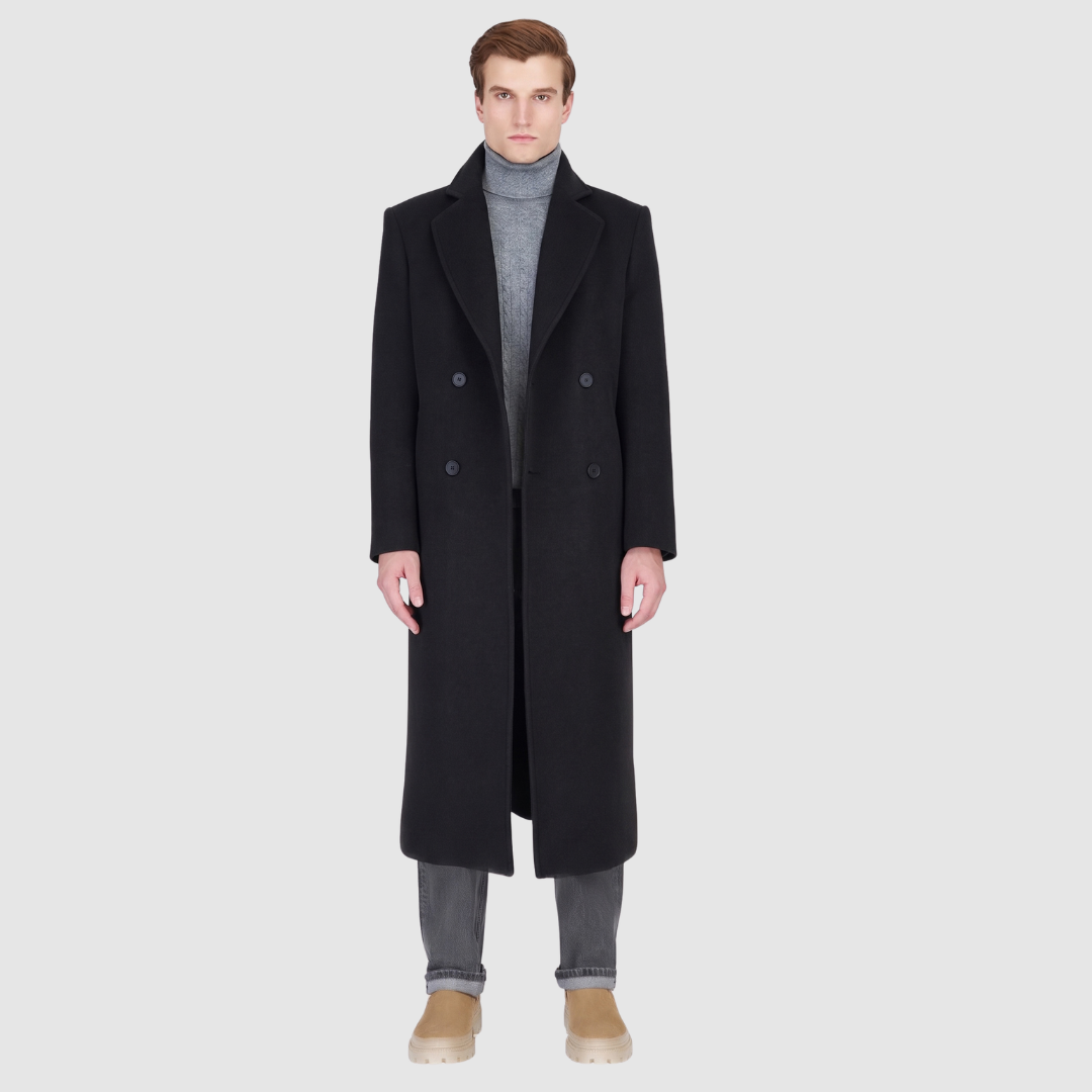The ATLAS Coat is an elongated double-breasted silhouette crafted from a premium wool blend in an camel melange hue. Designed with structured shoulders and a tailored regular fit through the body, it delivers sharp architectural lines and a refined drape. A wide notch lapel and double-breasted button closure give it a clean, minimalist finish, while discrete side welt pockets and a single back vent add classic functionality. Fully lined for comfort, ATLAS serves as a  statement piece for cold-weather