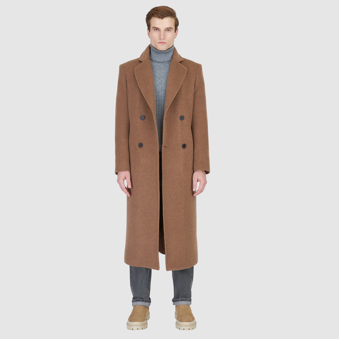 The ATLAS Coat is an elongated double-breasted silhouette crafted from a premium wool blend in an camel melange hue. Designed with structured shoulders and a tailored regular fit through the body, it delivers sharp architectural lines and a refined drape. A wide notch lapel and double-breasted button closure give it a clean, minimalist finish, while discrete side welt pockets and a single back vent add classic functionality. Fully lined for comfort, ATLAS serves as a  statement piece for cold-weather