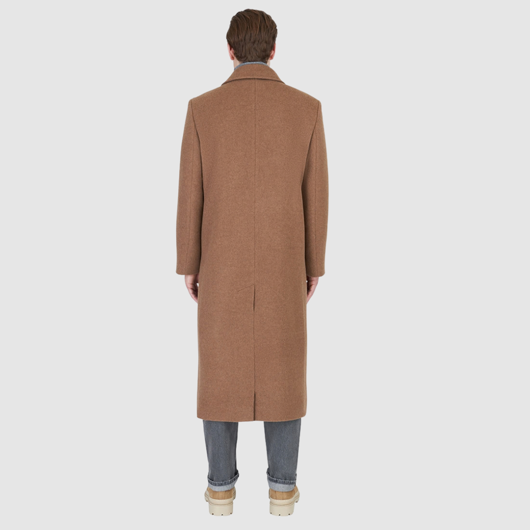 The ATLAS Coat is an elongated double-breasted silhouette crafted from a premium wool blend in an camel melange hue. Designed with structured shoulders and a tailored regular fit through the body, it delivers sharp architectural lines and a refined drape. A wide notch lapel and double-breasted button closure give it a clean, minimalist finish, while discrete side welt pockets and a single back vent add classic functionality. Fully lined for comfort, ATLAS serves as a  statement piece for cold-weather
