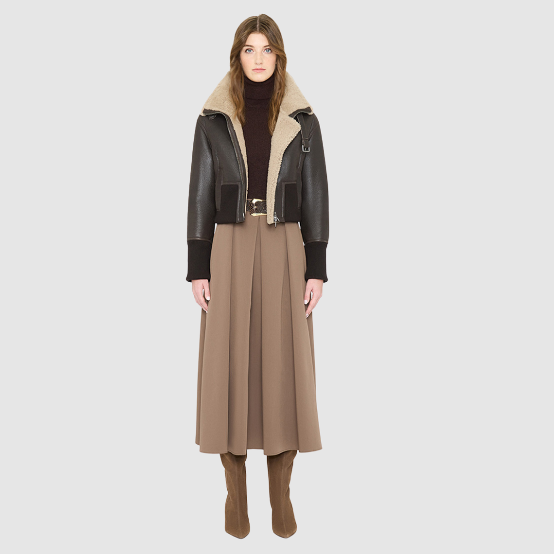 The CAVALLO delivers sharp alpine chic tailored for a metropolitan winter. This bomber jacket pairs rich brown matte nappa leather with a plush cream curly wool interior. Featuring integrated ribbed knit trim and a bold buckled collar, the cropped silhouette balances high-fashion utility with quiet luxury. Ideal for effortless layering, it moves easily from casual streetwear to an upscale cold-weather destination.