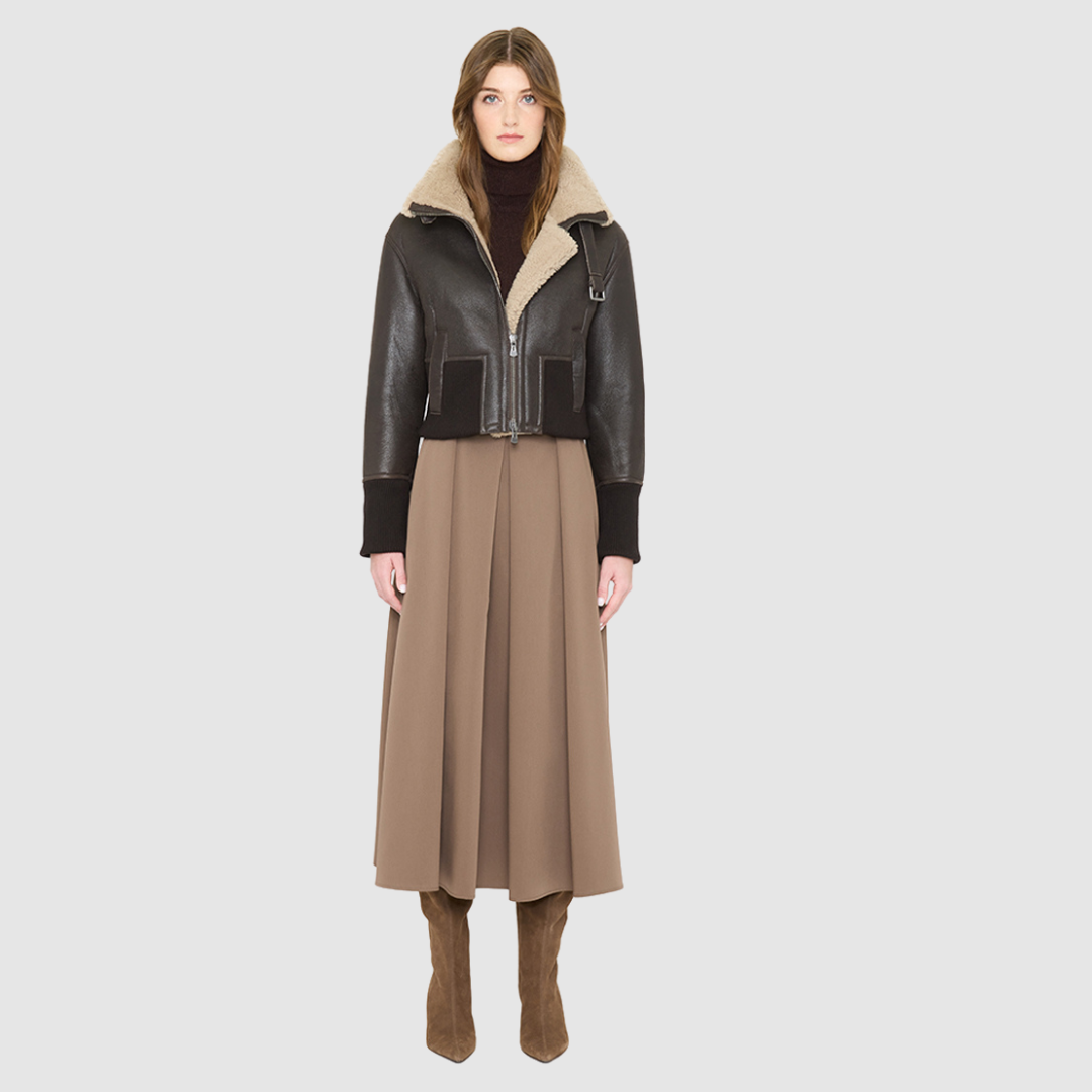The CAVALLO delivers sharp alpine chic tailored for a metropolitan winter. This bomber jacket pairs rich brown matte nappa leather with a plush cream curly wool interior. Featuring integrated ribbed knit trim and a bold buckled collar, the cropped silhouette balances high-fashion utility with quiet luxury. Ideal for effortless layering, it moves easily from casual streetwear to an upscale cold-weather destination.