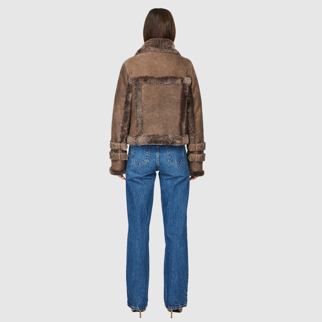 This cropped biker jacket is updated with contrasting wool seams. Crafted in genuine shearling, the jacket is finished with zip pockets and buckle accents at the collar and cuffs. Genuine Shearling Spread collar Long-sleeve Zipper closure Imported