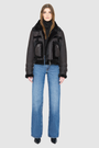 The DOLL Jacket is a heritage-inspired cropped shearling moto crafted from java semi suede leather with curly&nbsp;wool seam detailing for modern texture and dimension. Its regular shoulder and cropped silhouette create a sleek, contemporary fit, while buckle detailing on the collar and cuffs adds signature moto edge. Functional exterior and interior zip pockets and a front zip closure make DOLL as practical as it is stylish, perfect for après-ski layering or urban winter looks.