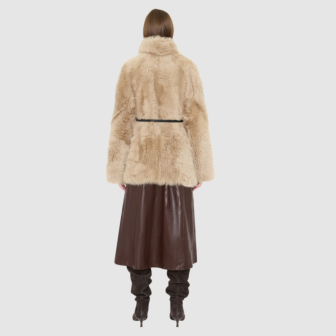 The HiSO GLO Jacket is a heritage-inspired mid-length shearling coat, masterfully crafted from premium semi curly toscana shearling for unparalleled texture and depth. Its regular shoulder and relaxed mid-length silhouette create an elegant, contemporary fit, while the dramatic, shawl collar frames the face with plush, long-haired wool. Designed with a versatile, reversible construction, this statement coat provides two distinctive looks in one