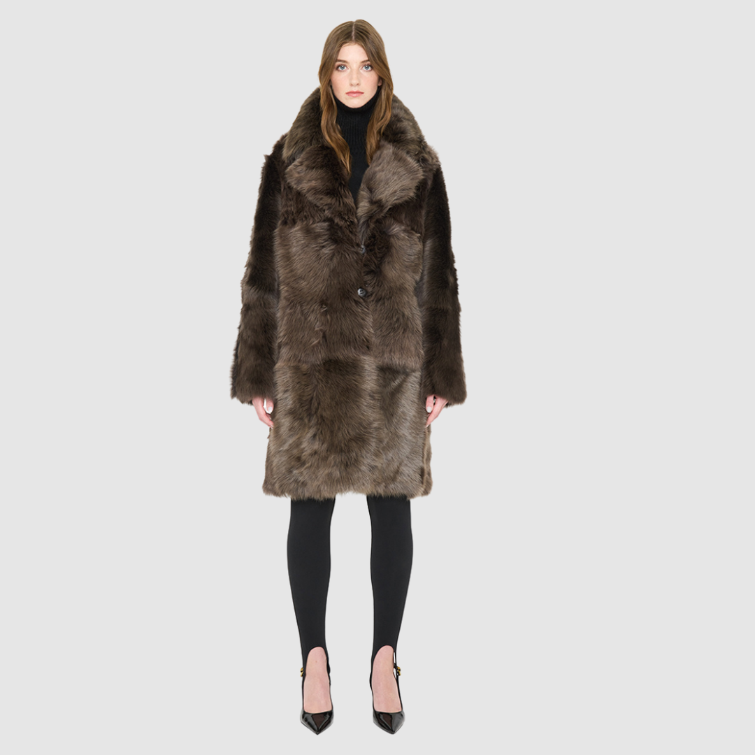 The JOY Jacket is a heritage-inspired reversible outerwear piece crafted in carbon suede shearling. Designed to flip seamlessly from plush oversized teddy to sleek suede, it offers versatile styling for both après-ski sophistication and everyday winter elegance. With a drop shoulder, large notch collar, and oversized silhouette, JOY combines comfort with modern edge. Functional slash side pockets on the teddy side and single welt pockets on the suede side, along with a front button closure, complete this lu