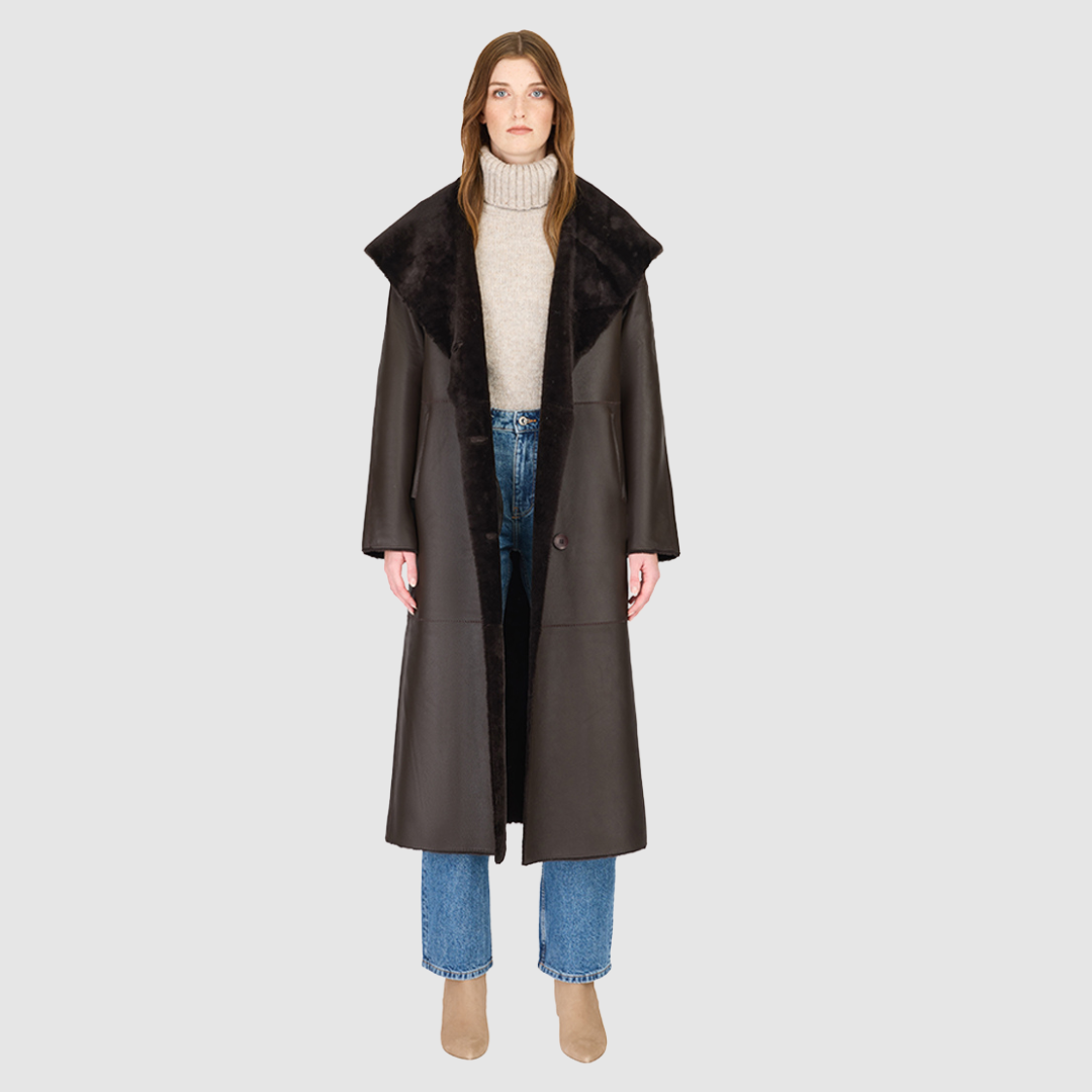 The MELONI Chocolate Silky Nappa Ironed Wool Jacket merges contemporary luxury with versatile, reversible design. Crafted from smooth nappa leather and plush ironed wool, this oversized coat offers two distinctive looks in one—sleek nappa for a modern finish and textured wool for cozy warmth. Its oversized hood converts to a dramatic shawl collar, while drop shoulders and a relaxed silhouette ensure comfort and ease of layering. Functional pull-through pockets and a refined button closure complete the coat