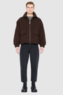 The MALCOLM Bomber Jacket is a modern silhouette crafted in a rich chocolate brown wool blend. Designed with drop shoulders and an easy, relaxed volume through the body, it delivers architectural presence and effortless style. A high convertible spread collar and two-way front zip closure give it a clean, minimalist finish, while oversized front flap patch pockets and elasticized cuffs and hem define the shape. Fully lined for comfort, MALCOLM serves as a definitive statement piece for cold-weather layering