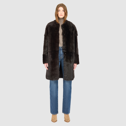 The ALLORA Jacket is a luxury reversible shearling teddy crafted in chocolate silky Toscana for a rich and modern finish. Designed as a collarless oversized silhouette, it effortlessly flips from plush wool-out shearling to a sleek nappa skin-out jacket, offering two looks in one. With its generous fit through the shoulders, arms, and torso, ALLORA balances comfort and style. Functional slash side pockets on both sides and a front snap closure complete this elevated women’s reversible shearling jacket.